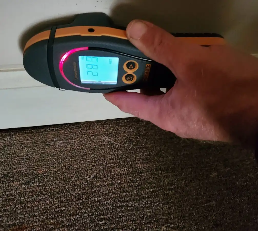 Moisture detection at baseboard during Storm Damage Restoration in Carroll